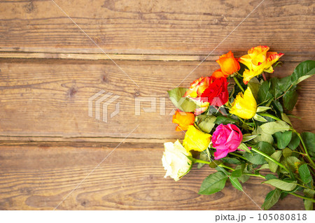 Roses bouquet on the old brown wooden background. Top view with copy space. 105080818