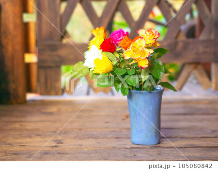 Early spring stil life with a bouquet of colorful roses on the old wooden background. 105080842
