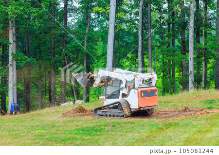 Ground is moved in bulldozer while landscaping work being performed 105081244