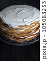 a whole round honey cake on a stand against a dark background 105083253