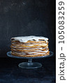 a whole round honey cake on a stand against a dark background 105083259
