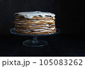 a whole round honey cake on a stand against a dark background 105083262