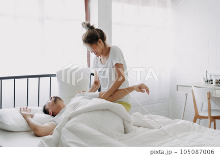 Funny lovely couple. Wife trying to wake husband up in the morning. 105087006