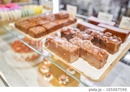 A variety of cakes covered with chocolate and decorated with pistachio mousse. A showcase in a pastry shop with delicious desserts with fresh berries and cream. Delicious pastries in the coffee shop. A variety of cakes covered with chocolate and decorated with pistachio mousse. A showcase in a pastry shop with delicious desserts with fresh berries and cream. Delicious pastries in the coffee shop. 105087598