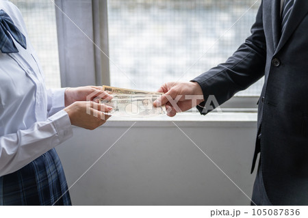 闇バイト・カツアゲ・恐喝・いじめのためお金のやり取りをする女子高生と男性 闇バイト・カツアゲ・恐喝・いじめのためお金のやり取りをする女子高生と男性 105087836