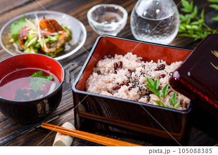 お重に盛り付けた赤飯（日本酒を添えて）  105088385