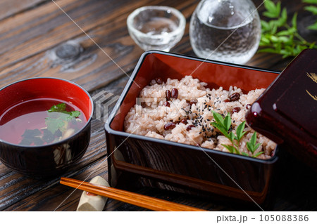 お重に盛り付けた赤飯（日本酒を添えて）  105088386