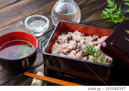 お重に盛り付けた赤飯（日本酒を添えて）  105088387