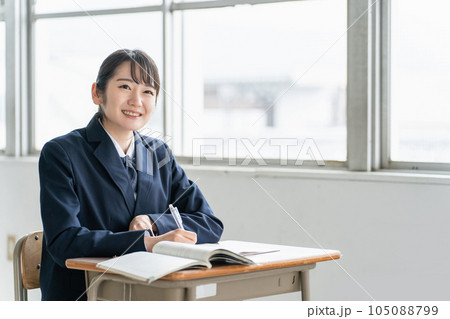学校の教室で英語の教科書・参考書を見ながら勉強する女子高校生・中学生の生徒 学校の教室で英語の教科書・参考書を見ながら勉強する女子高校生・中学生の生徒 105088799