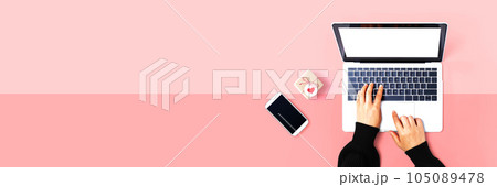 Person using a laptop computer with a small gift box 105089478