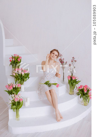 Smiling woman feels joy and happiness, holds a pink tulip. 105089903