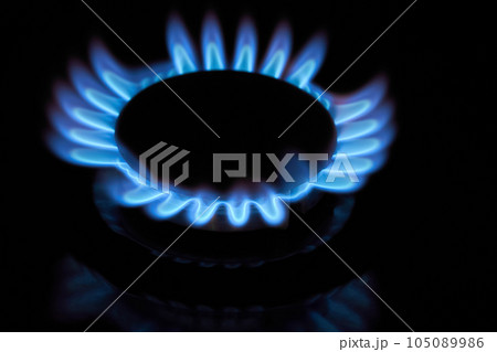 Flaming gas burner on household kitchen stove in the darkness 105089986