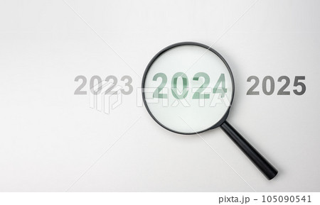 2024 inside of Magnifier glass on white background for focus current situation, positive thinking mindset concept. 2024 present in focus. 2023 2024 2025 105090541