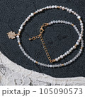 lucky clover pendant on white beads necklace. black textured background. festive bijuoterie for party. 105090573