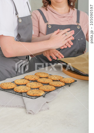 woman chef teaching how to cook her teenager son. making chocolate chip biscuits at home , family together spending time cooking at holiday. 105090597