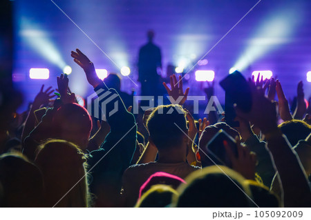Unrecognizable people showing raised hand gesture to artist on stage in live concert Unrecognizable people showing raised hand gesture to artist on stage in live concert 105092009