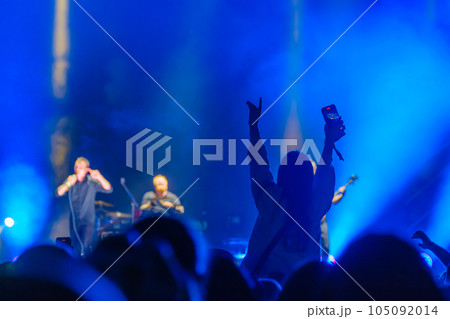 Unrecognizable spectator standing and showing hand to concert performers on stage in neon lights Unrecognizable spectator standing and showing hand to concert performers on stage in neon lights 105092014