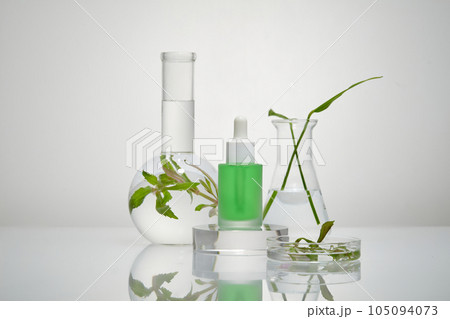 Dropper bottle full of green fluid is standing on a transparent podium. Branding mockup design. Seaweed can improve skin tone and pigmentation Dropper bottle full of green fluid is standing on a transparent podium. Branding mockup design. Seaweed can improve skin tone and pigmentation 105094073