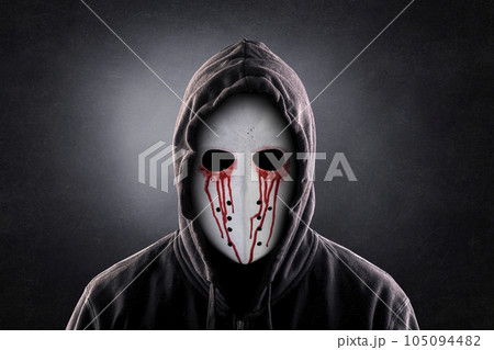 Spooky figure in blood with hooded cape over dark misty background 105094482