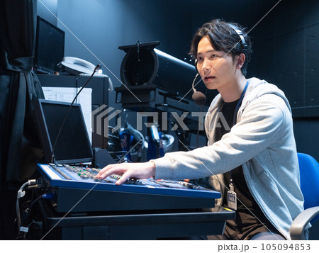 ホールの照明室で照明の調整をする若い男性 105094853