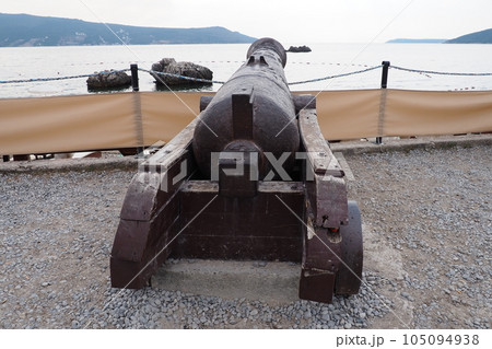 A cannon, a throwing device, a type of artillery gun for firing at a flat trajectory, as well as at air and sea targets. Cast iron old cannon in Herceg Novi, Montenegro. Naval artillery. Coastal gun A cannon, a throwing device, a type of artillery gun for firing at a flat trajectory, as well as at air and sea targets. Cast iron old cannon in Herceg Novi, Montenegro. Naval artillery. Coastal gun 105094938