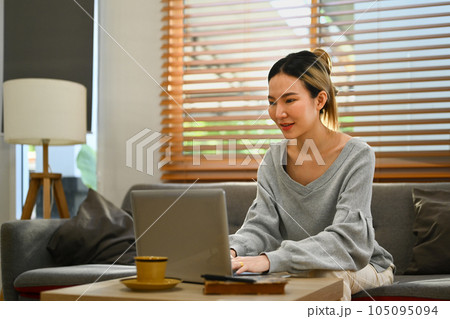 Attractive young woman using laptop at home, browsing internet, watching movie and shopping online Attractive young woman using laptop at home, browsing internet, watching movie and shopping online 105095094