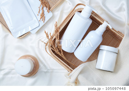 Bathroom concept with set of product bottles unbranded and jar of salt bath decorated on bamboo basket on silk fabric background. Top view, mockup for design packaging 105097448