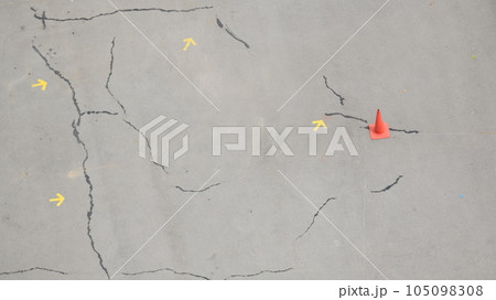 crack road texture background with arrow and cones 105098308
