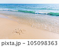 The drawing of the sun on sand beach with soft waves 105098363