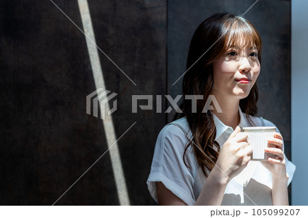 日差しがさしこむ部屋でコーヒーを飲む女性 105099207