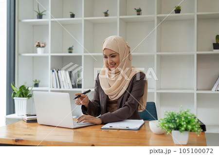 portrait of focused Muslim businesswoman working on computer in office 105100072