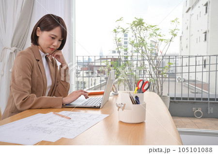 屋内の机でノートパソコンの操作をする若い女性 屋内の机でノートパソコンの操作をする若い女性 105101088