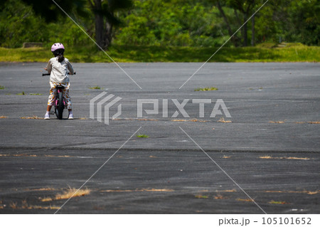 自信なさそうに公園で一人で自転車の練習をする少女 105101652