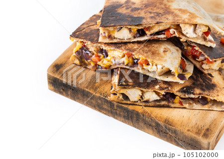Mexican quesadilla with chicken, cheese and peppers isolated on white background Mexican quesadilla with chicken, cheese and peppers isolated on white background 105102000