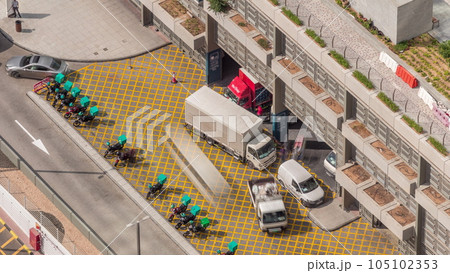 Row of food delivery service motor bikes in Dubai street aerial timelapse. 105102353