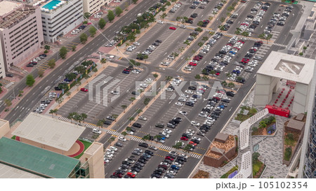 Aerial view of many colorful cars parked on parking lot with lines and markings for parking places all day timelapse. Dubai Aerial view of many colorful cars parked on parking lot with lines and markings for parking places all day timelapse. Dubai 105102354