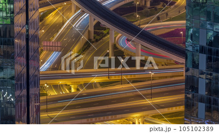 Aerial view from above to a busy road junction in Dubai night timelapse. 105102389
