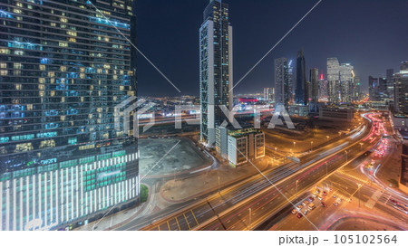 Many towers and skyscrapers with traffic on streets in Dubai Downtown and financial district night timelapse. 105102564