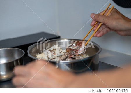 圧力なべで作った鯛めしの、鯛をほぐしている男性の手元 圧力なべで作った鯛めしの、鯛をほぐしている男性の手元 105103456