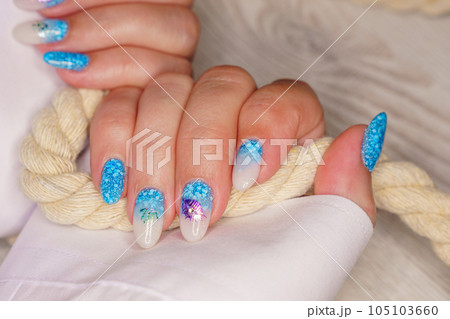 Manicure in the marine style. Photos with beautiful well-groomed female nails. Selective focus. Manicure in the marine style. Photos with beautiful well-groomed female nails. Selective focus. 105103660