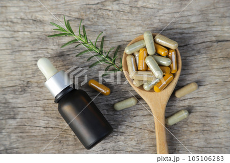 Herbal medicine in capsules from herb leaf on rustic wooden table with copy space for medical background. healthy eating with natural product for good living. 105106283