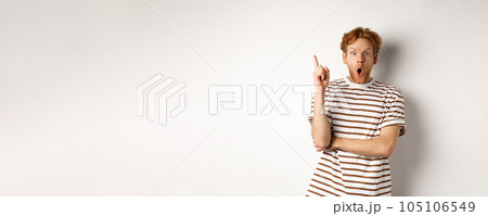 Excited redhead man having revalation, raising finger in eureka sign and saying idea, standing over white background 105106549