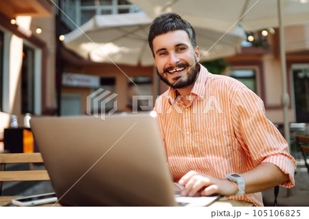 Man with laptop and phone sits in cafe and works. Business, blogging, freelance, education concept. 105106825