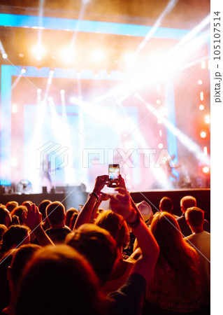 Hand with a phone records live music festival. People taking photographs with smart phone. Hand with a phone records live music festival. People taking photographs with smart phone. 105107514