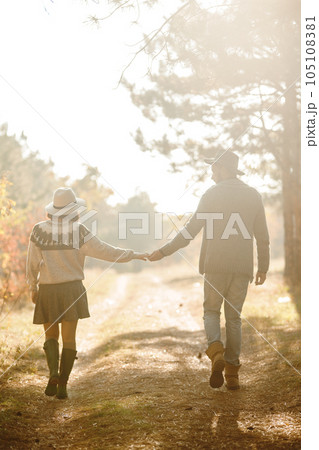 Lovely hipster couple looking at each other. Couple wearing beautiful hats and sweaters. 105108381