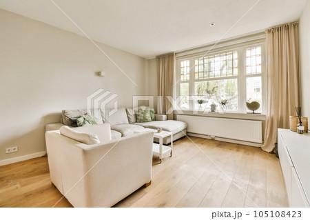 a living room with wood flooring and white couches in the room is very clean, but there is no furniture a living room with wood flooring and white couches in the room is very clean, but there is no furniture 105108423