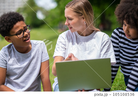 Blonde girl helping teens with their project work Blonde girl helping teens with their project work 105108536