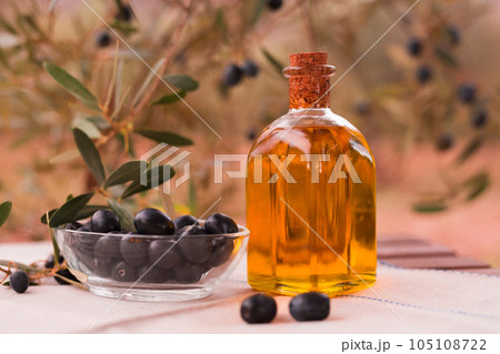 Olive oil in a glass bottle and green olives 105108722