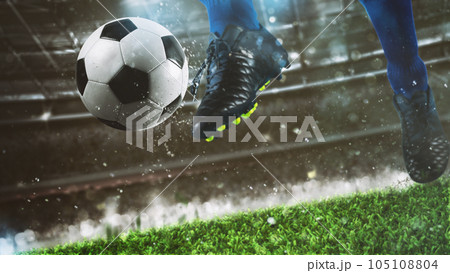 Football scene at night match with close up of a soccer shoe hitting the ball with power Football scene at night match with close up of a soccer shoe hitting the ball with power 105108804