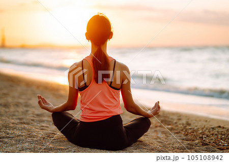 Meditation. Young woman doing yoga near the ocean barefoot. Calmness and balance, healthy lifestyle. Meditation. Young woman doing yoga near the ocean barefoot. Calmness and balance, healthy lifestyle. 105108942